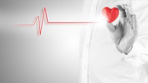 Healthy heart and cardiology concept with a cardiogram linked to red heart.